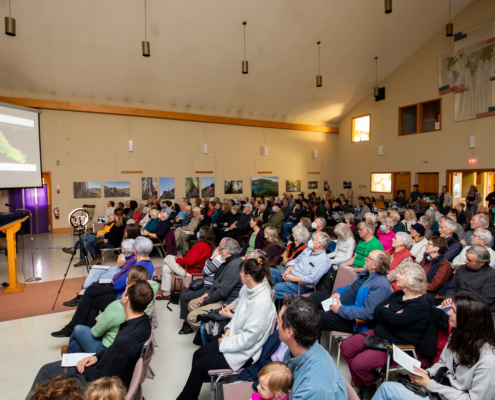 About 200 people listening intently as renowned forest ecologist Andy MacKinnon presents about old-growth forests vs. second-growth tree plantations
