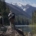 Two people stand on a rock by the Fraser River in Kanaka Bar territory.